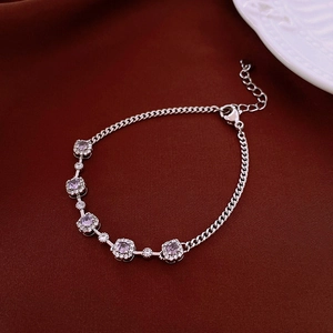 Dettaglio macro del bracciale d'argento con cinque zirconi viola e micro cristalli