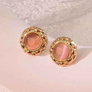 Vintage gold-rimmed round earrings with pink stone and quilted texture detail