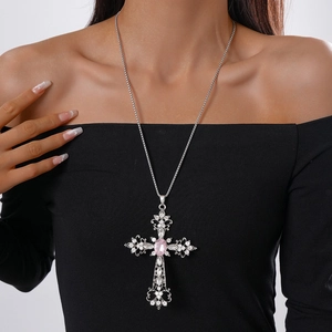 Baroque silver cross necklace with pink gemstone and rhinestones on a female model