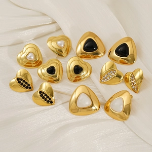 Detail of vintage 18k gold heart earrings with black onyx and pearl inlays
