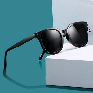 Classic square black sunglasses with thick frames and metal rivets on white pedestal