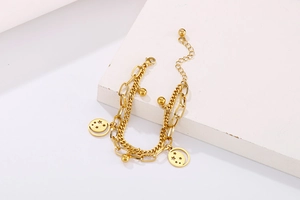 Detail of double-layer gold stainless steel bracelet with star moon pendants and beads