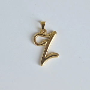 Gros plan détaillé d'un pendentif lettre Z en acier inoxydable plaqué or 18 carats poli