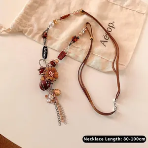 Close-up of bohemian pendant necklace with wood beads and engraved vintage star charms