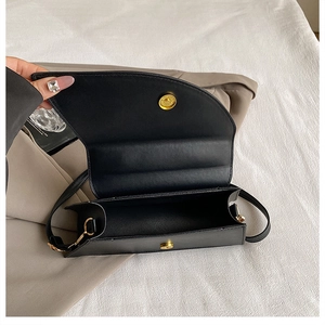 Detail view of the black leopard pattern square bag with gold magnetic snap closure