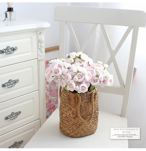 Close-up of four bundles of dark pink artificial camellias in a woven basket