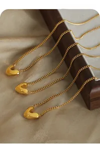 Vue macro détaillée de trois pendentifs cœur en V dorés avec une finition polie