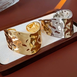 Détails macro de bracelets joncs martelés irréguliers en métal doré et argenté poli