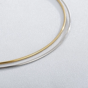 Detail of 2mm minimalist stainless steel neck rings in gold and silver finishes