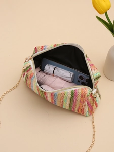 Colorful woven crossbody camera bag with gold chain showing internal storage capacity
