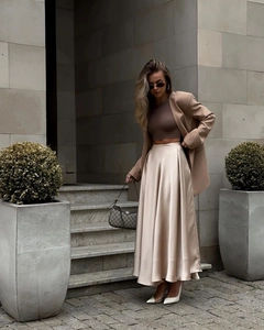 Detail of elegant champagne satin high waist maxi skirt with smooth silky texture
