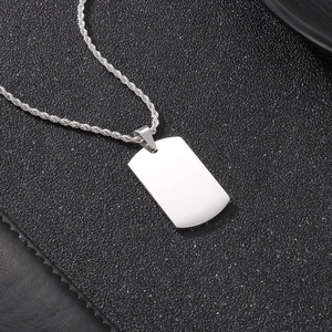 Détail macro du pendentif carré poli en acier inoxydable et chaîne corde sur cuir noir