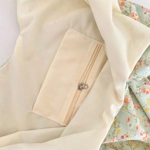 Detail of floral canvas bag showing smooth inner lining and zipper pocket for storage