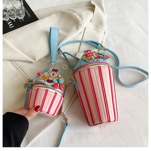 Detail of creative dessert-cup crossbody bag with colorful stripes and miniature charms