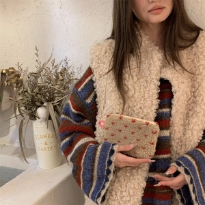 Close-up of plush lamb wool organizer pouch with red heart embroidery and pink ring hook