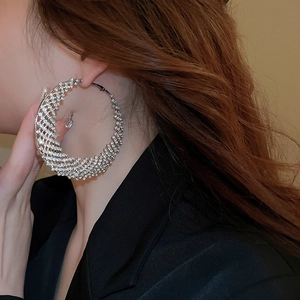 Dettaglio della modella con orecchini a cerchio in argento e strass scintillanti