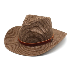 Detail of the woven paper straw texture and metal M logo on a brown cowboy hat