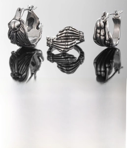 Close-up of gothic stainless steel skull palm earrings with oxidized vintage silver finish