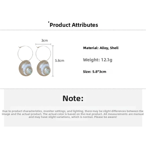 Detail view of large hoop earrings with conch shell pendants and size measurements