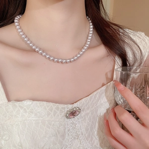 Close-up of French vintage style light purple pearl necklace on woman neck