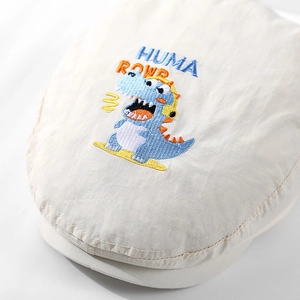 Gebroken witte kinderbaret met geborduurde dinosaurus en HUMA ROWR-belettering