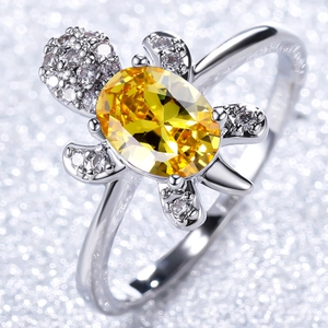 Elegant turtle ring featuring a large yellow gemstone and white pavé cubic zirconia