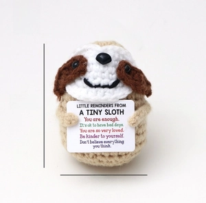 Detail view of handmade crochet sloth doll holding motivational card with size dimensions