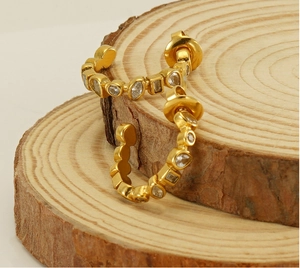 Detailed view of 18k gold C-shape earrings with marquise and round cubic zirconia inlay