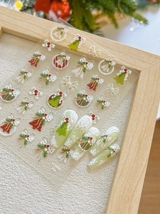 Detail view of 3D Christmas nail stickers with tree and wreath patterns on white background