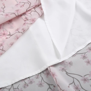 Détail du tissu en mousseline à imprimé cerisier et doublure blanche pour la robe