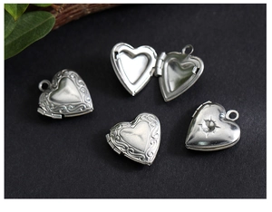 Macro shot of silver-toned heart locket with intricate vintage vine engraving details