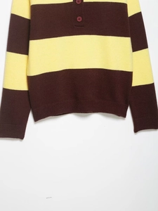 Detail des braun-gelb gestreiften Strickpullovers mit Knopfkragen und gerippten Ärmelbündchen