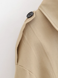 Detail of khaki trench coat shoulder with twill texture and black resin button