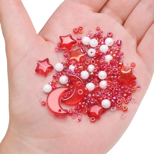 Close-up of star and moon acrylic beads held in hand for DIY jewelry making sets