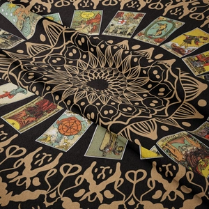 Close-up of tarot card tapestry showing The Star and The World gold pattern on black fabric