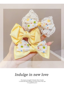 Close-up of three sweet bows including yellow satin, polka dot, and lace ribbons