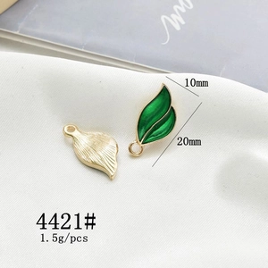 Detail view of 10x20mm alloy leaf pendant charms in gold and green enamel for DIY jewelry
