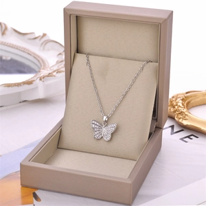 Elegant silver butterfly pendant necklace with white zircons in a beige jewelry box
