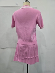 Vue arrière d'un ensemble deux pièces en tricot rose avec polo et jupe plissée