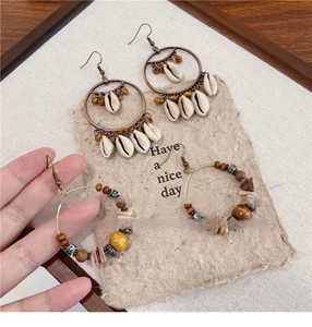 Detail of bohemian shell and seed bead tassel earrings with vintage bronze hooks