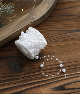 Close-up of white faux pearl beads on a spool for DIY Christmas wedding decoration