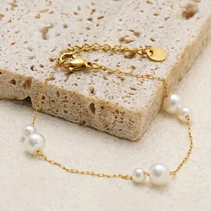 Bracelet élégant en acier inoxydable doré avec perles d'eau douce sur un socle en pierre