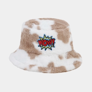 Detail of plush faux fur cow print bucket hat featuring a colorful WOW embroidery patch