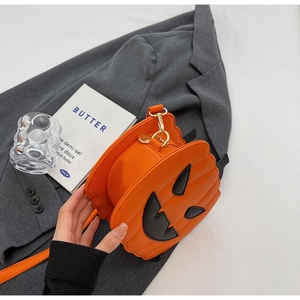 Detail of creative orange pumpkin shoulder bag with zipper closure on gray blazer fabric