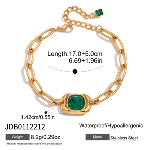 Detail of gold chain bracelet with green zircon and lobster clasp in stainless steel