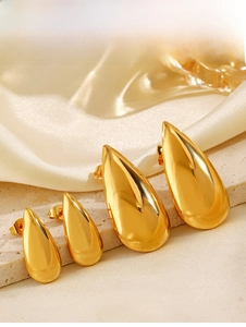 Polished 18K gold teardrop earrings in four sizes displayed on a luxury stone podium