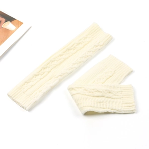 Detailed close-up of cream knit leg warmers showing classic cable stitch texture