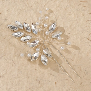 Spilla per capelli da sposa con cristalli argentati e perle su sfondo beige