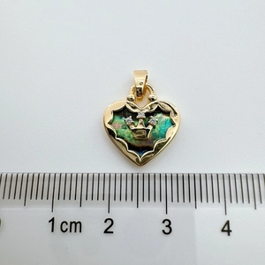 Macro shot of 18K gold-plated heart pendant with abalone shell and crown detail
