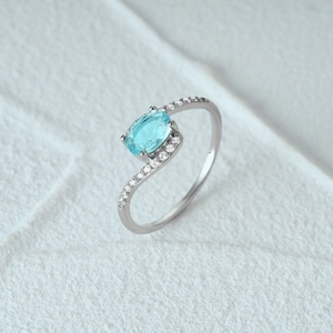 Detailed macro shot of an S925 silver ring featuring an oval light blue gemstone and clear side stones